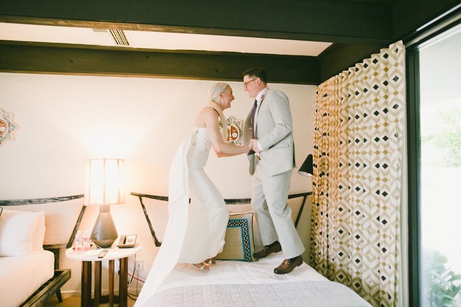 A candid photo of a couple joyfully jumping at their wedding at the Parker Palm Springs