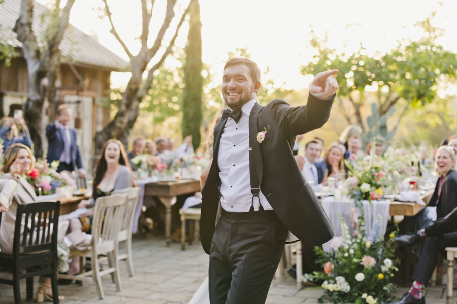 A groom smiles and dances