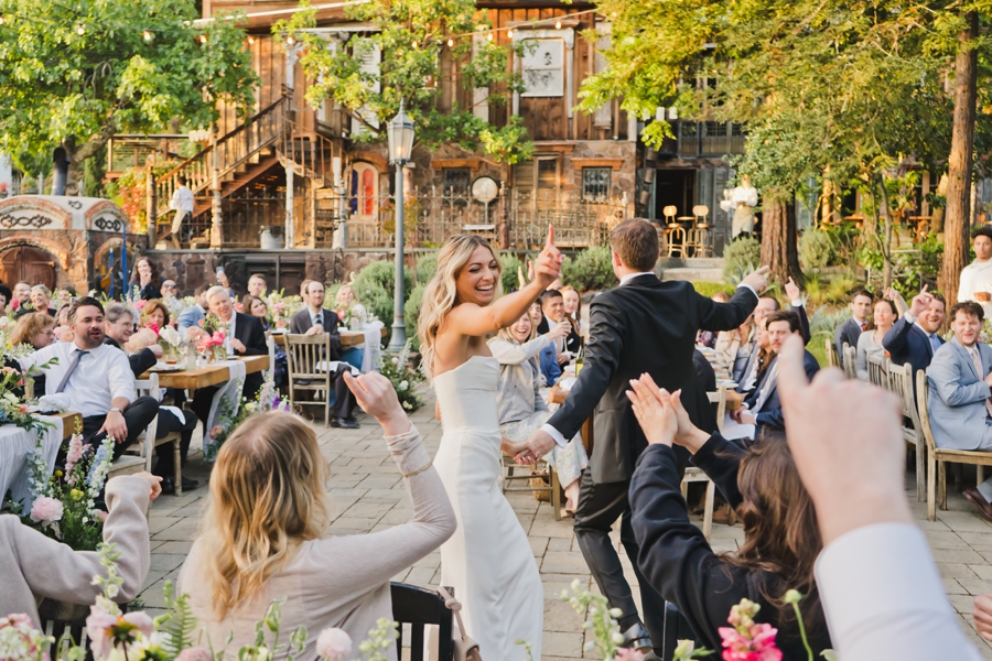 A bride smiles and dances outside