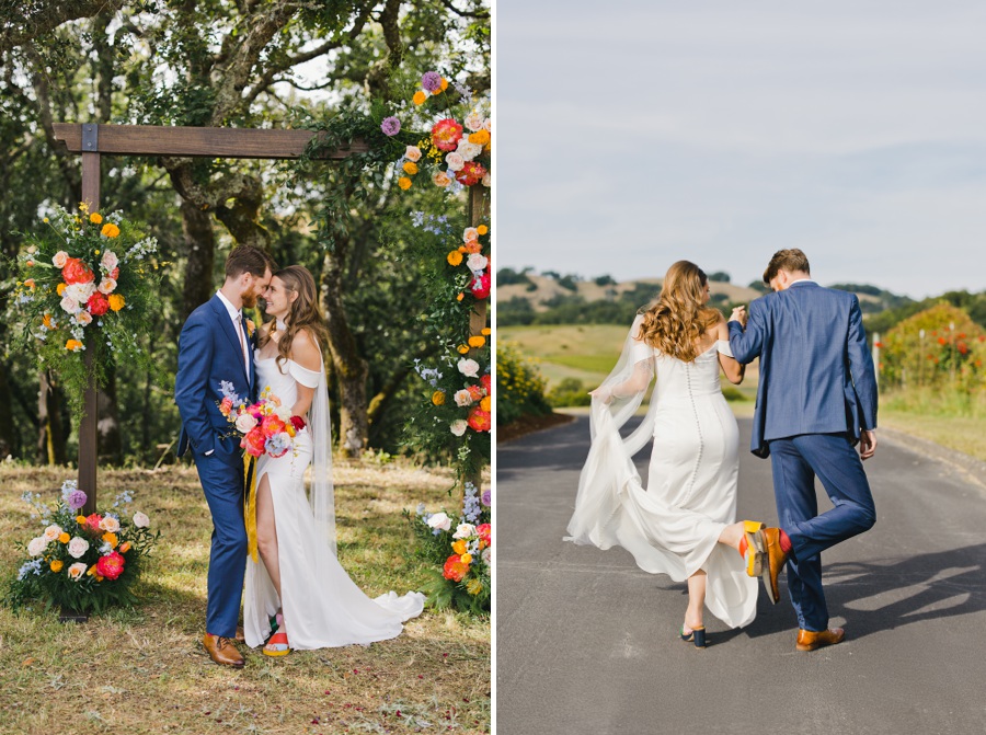 A bride and groom stand together under a floral arch outdoors; in the next image, they walk away together on a road, playfully kicking up their feet.