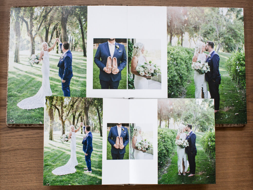 An open wedding album displays images of a bride and groom outdoors, holding flowers and shoes, and posing together in a grassy, wooded area.